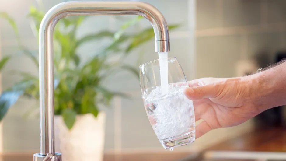 Wasserhahn, aus dem Wasser in Glas fließt